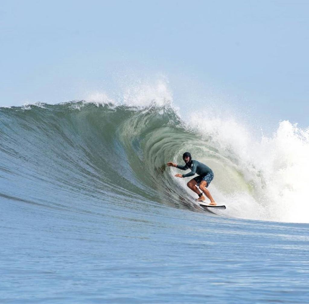 Surfer walking along Costa Rica beach